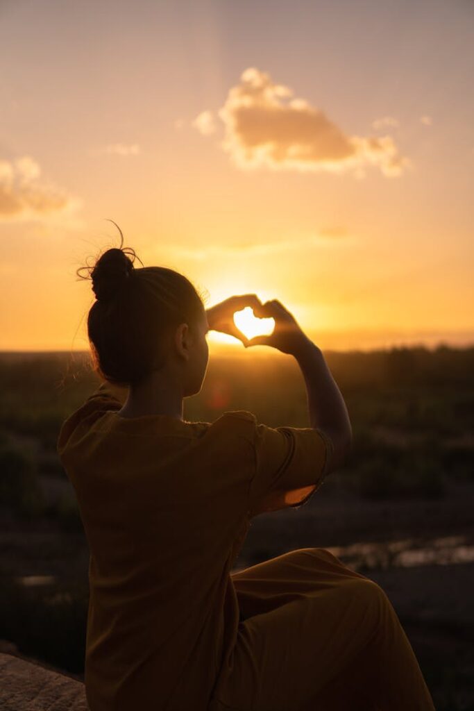 pexels-photo-1535288 Silhouette of a person forming a heart with hands against a Morocco sunset.